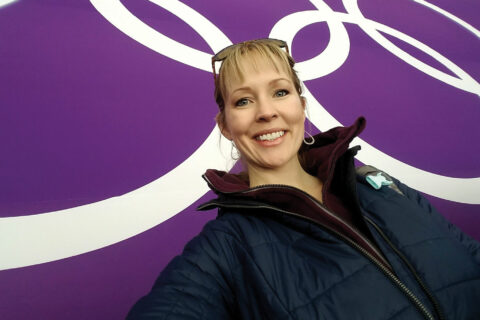 Kelly VanderBeek in front of the Olympic Rings