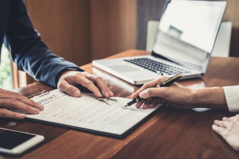 Two people sign a mortgage document on the way to becoming mortgage free