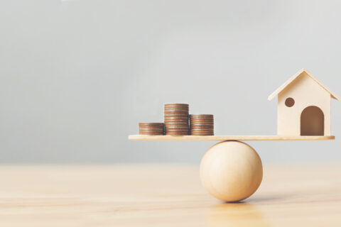 A house balanced with pennies to show home equity