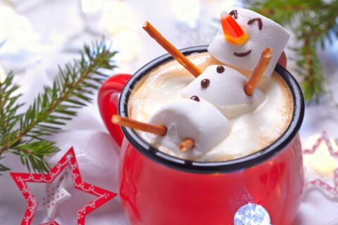 A snowman made of marshmallows floats in a hot chocolate in a red mug. It's a cute image that made us smile.