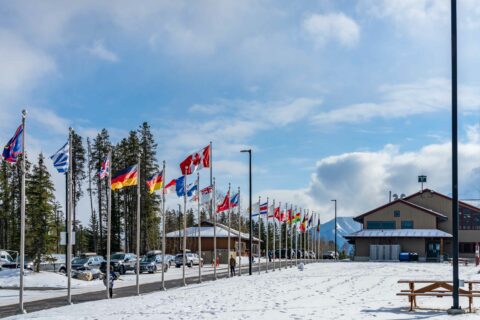 Flags blow in the wind by the lodge at the Canmore Nordic Centre Provincial Park