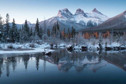 A winter scene of the Three Sisters from the Bow River to represent why we need eco-friendly ways to heat our homes.